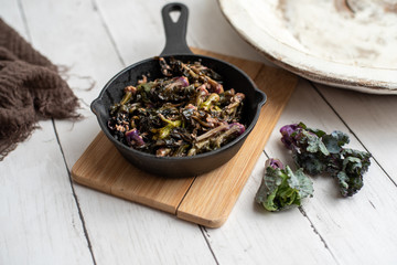 Sautéed kalettes, cooked in butter and garlic in a cast iron pan.