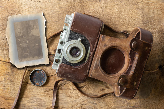 Collage of ancient old vintage film camera with old lether cover on brown old wood backgroundand and sepia photo. Antique, vintage, grunge, classic concept