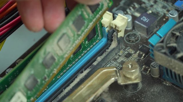 Service for repair and cleaning of computer equipment. the master takes out a dusty memory card from the motherboard.