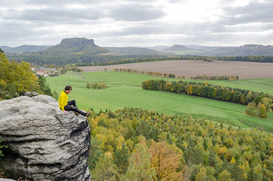 Deutschland, Sachsen, S&auml;chsische Schweiz, Wanderung von Wehlen &uuml;ber die Rauensteine, Wanderer sitzt am Felsen &uuml;ber dem Abhang, Blick von den Rauensteinen auf den Lilienstein