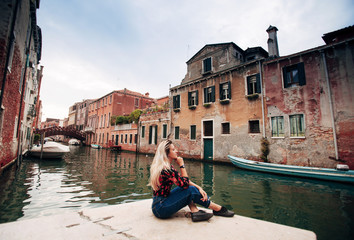 Fototapeta na wymiar girl sitting on a street of Venice