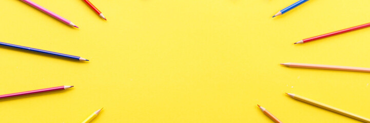 Colorful pencils on the yellow background outer space for text place