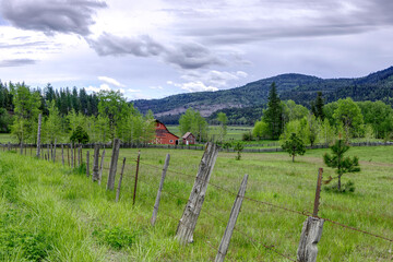 Fototapeta na wymiar Red barn in a green field.