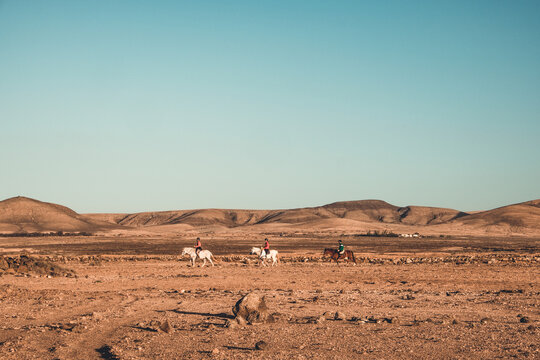 Spanien, Kanaren, La Oliva, Auf der Insel Fuerteventura. Die Hausberge von El Cotillo. von El Cotillo bei Sonnenuntergang. Eine Gruppe von Reitern ist noch unterwegs