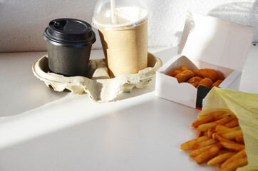 Yummy French fries, chicken Nuggets, , milkshake, sauce, latte and espresso. paper bag, white background. Binge eating. food delivery