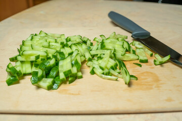Delicious fresh sliced cucumber on a wooden cutting Board with a knife