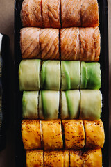 Freshly cooked sushi chef, delicious big rolls with avocado, cheese, salmon, sesame seeds 