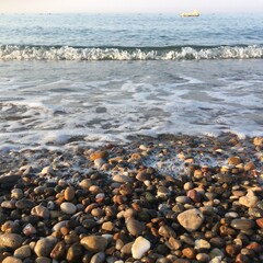 Pebbles by the sea close-up, earlier morning in Turkey. Mobile photo and selective focus.