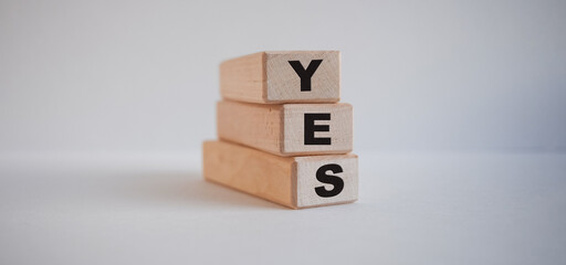 inscription yes on wooden cubes on white background