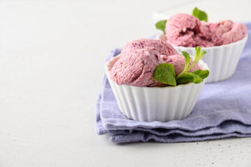 Homemade blueberry and blackcurrant ice cream in bowls on white background. Close up. Space for text.
