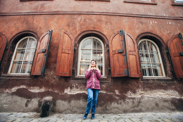 Fototapeta na wymiar girl near large wooden windows with shutters