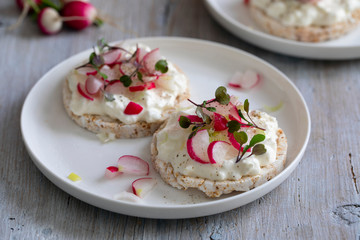 Obraz na płótnie Canvas Rice crackers with cottage cheese, radish and micro herbs