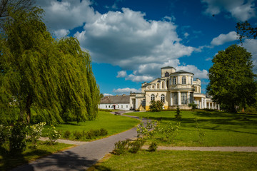 Fototapeta na wymiar Boczne skrzydło pałacu wtopione w tło parku w Rejowcu