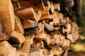 Rolgordijnen Close-up van gehakt brandhout in een stapel klaar voor het branden. © Anna Lipman