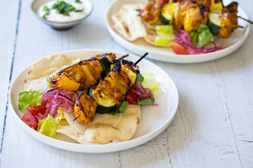 Chicken and courgette spicy tandoori skewers with salad and flat bread