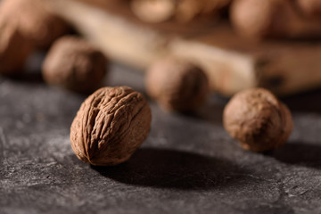 Fresh walnuts on a dark textured background.