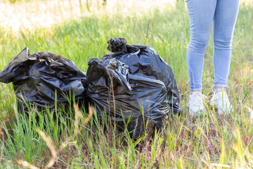 hands in rubber gloves putting household waste in a small bin bag