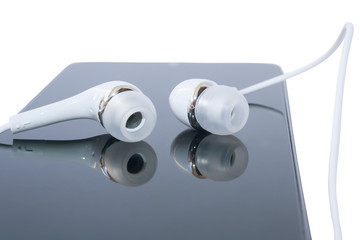 A pair of white headphones lying on the smartphone close-up.Isolated on a white background.