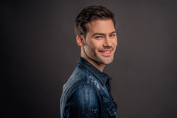 Advertisement concept, side view half face profile with copy space of perfect smiling man standing over gray background