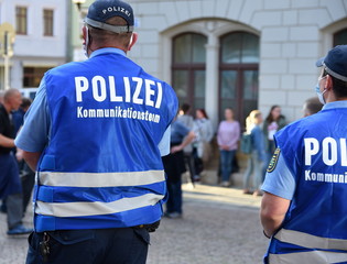 Polizeibeamter mit blauer Weste und Aufschrift: 