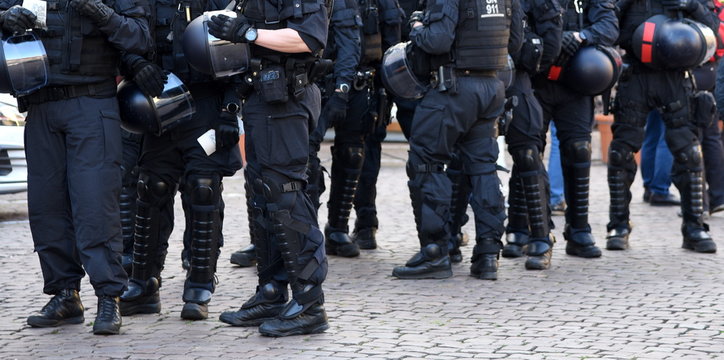 Schwarz uniformiertes Polizeiaufgebot in voller Ausrüstung auf einer Demo