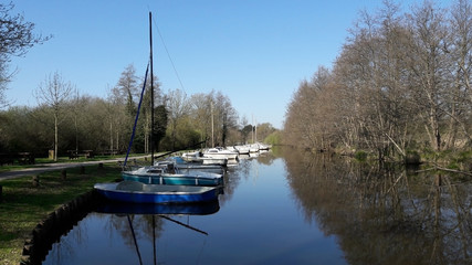 Boats by the calm river in sunny day