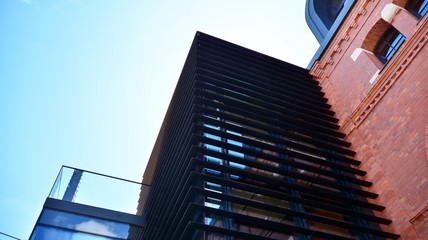 Structural glass wall reflecting blue sky. Abstract modern architecture fragment. View of a modern glass skyscraper, modern office building. Modern office facade fragment with blue glass.