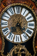 Vieille horloge en bois et dorures au style baroque