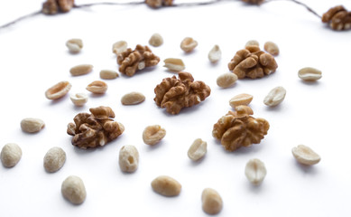 Many crushed walnuts lie on a white background in a wooden frame. Decorative photo frame. Abstraction.