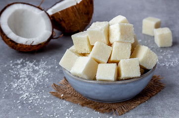 White Coconut Fudge in a bowl on on  gray concrete background  with copy space. Healthy, vegetarian, dairy free dessert concept