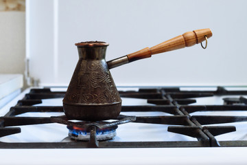 
ground coffee is brewed in a Turk on a gas stove