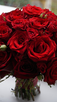 Red wedding bouquet on the windowsill
