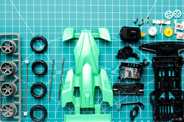Flatlay mini 4WD toy car awaiting to be assemble on cutting mat. Popular toy car during 90's.