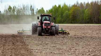 Obraz premium A man on a tractor prepares land for sowing