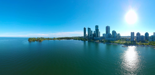Obraz premium Artistic creative view of Humber Bay Shores Park city view and green space with skyline cityscape, azure lake Ontario. Skyscrapers over The Queensway on sunset at summer, Etobicoke, Ontario, Canada
