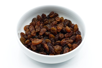 Dried raisins in a white bowl isolated on white background