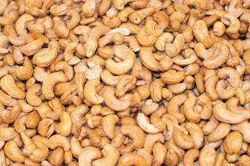 Tasty cashew nuts fried as background, top view