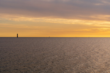 Naklejka premium Sunset with the old lighthouse Svinbadan in silhouette built in 1958 and located in Oresund, Viken, Scania, Sweden.