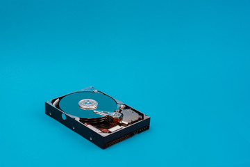 Top view of the inside of a Hard Drive on blue background. data storage concept. Topical data storage unit repairs. information backup and security concept. file recovery services