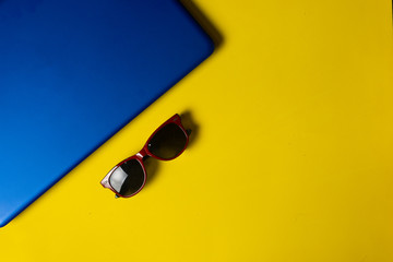 sunglasses and laptop on yellow background. Telework concept. Modern lifestyle. topic of traveling and working. online job concept. Good vibes expression. Copy space