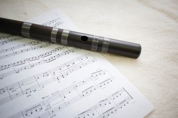 Wooden flute and music sheet