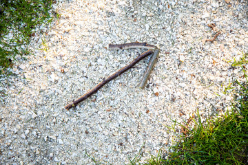 Wooden stick arrow sign at forest white gravel stone path. Scavenger hunt game. Nature way finding concept. Woodlands playground ecology background