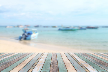 Wood table top with blurred boat at the beach