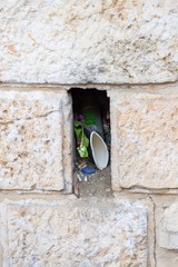 Niche or hole with garbage in the old wall in Jerusalem, Israel. Details, copy space
