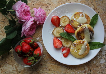 strawberry and cream. Cottage cheese pancakes cottage cheese with strawberry, mint, and banana. Ukrainian traditional food. Ukrainian national kitchen.