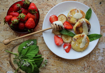 strawberry and cream. Cottage cheese pancakes cottage cheese with strawberry, mint, and banana. Ukrainian traditional food. Ukrainian national kitchen.