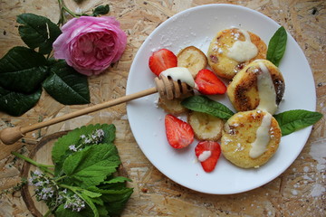 strawberry and cream. Cottage cheese pancakes cottage cheese with strawberry, mint, and banana. Ukrainian traditional food. Ukrainian national kitchen.