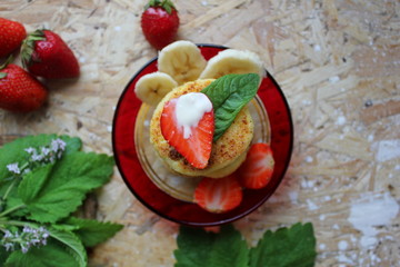 strawberry and cream. Cottage cheese pancakes cottage cheese with strawberry, mint, and banana. Ukrainian traditional food. Ukrainian national kitchen.