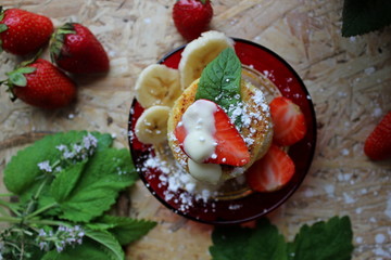 strawberry and cream. Cottage cheese pancakes cottage cheese with strawberry, mint, and banana. Ukrainian traditional food. Ukrainian national kitchen.