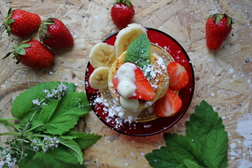strawberry and cream. Cottage cheese pancakes cottage cheese with strawberry, mint, and banana. Ukrainian traditional food. Ukrainian national kitchen.